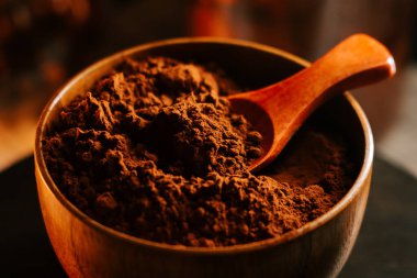 Kakao tozu ahşap bir kasede, kaşık pişirmeye ve pişirmeye hazır