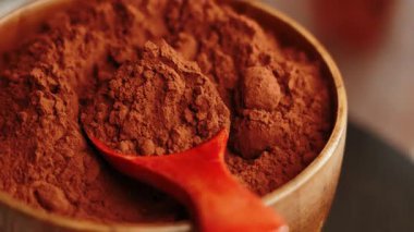 Kakao tozu ahşap bir kasede. Mutfakta pişirme ve pişirme için kaşık var.