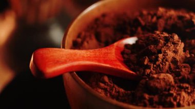 Kakao tozunu, arka planda bir kaşıkla ahşap bir kasede keşfediyorum.