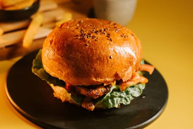 Salata ve pastırmalı sulu burger. Basit bir tabakta, parlak bir tabakta.