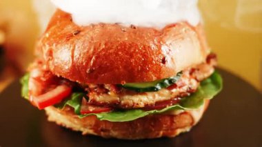 Sıcak bir ortamda taze malzemelerle yapılmış lezzetli bir burgerin tadını çıkarıyorum.