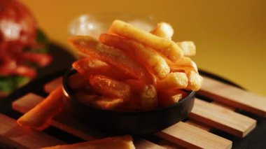 Lezzetli patates kızartmaları ahşap bir tabakta servis ediliyor.