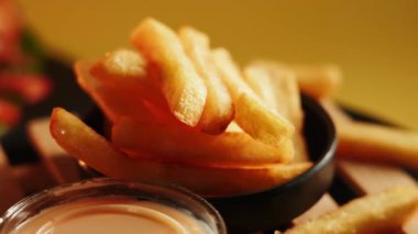 Gevrek patates kızartmasının tadını çıkarıyorum. Lezzetli bir sosla servis ediliyor.