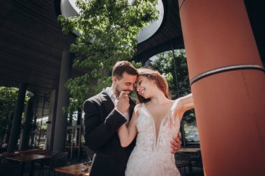 Çiftler düğün günü yakınlarındaki yeşillikli modern bir mekanda keyifli bir anı paylaşıyorlar.