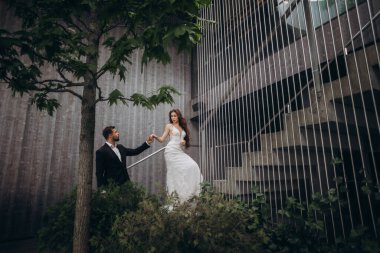 Bir çift düğün kutlaması sırasında birlikte bir binanın merdivenlerinde yürür.