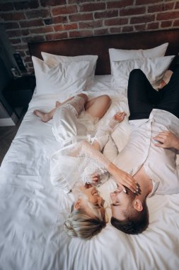 Çift, gecenin geç saatlerinde rahat bir yatak odasında rahatlamak ister.