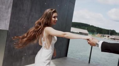 Düğün çifti göl kıyısındaki mekanda güneşli havada eğleniyorlar.