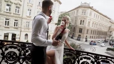 Çiftler tarihi şehir ortamında akşam saatlerinde balkonda kırmızı şarap içmeyi severler.