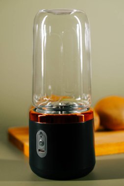 Taşınabilir blender evde meyve suyu yapmak için mutfak tezgahının yanına oturur.
