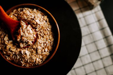 Tabak yulaf ezmesi ve ahşap kaşıkla dolu.