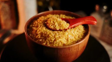 Bulgur yemek pişirirken kaşıkla bir kasede gösterilir.