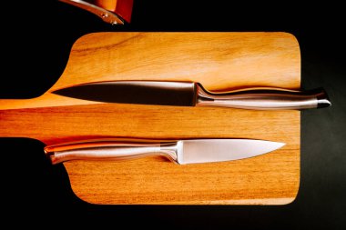 Akşam ışığı altında mutfak kurulumunda tahta tahtada duran bıçaklar.