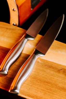 Bıçaklar ahşap kesme tahtasına yerleştirilmiş ve mutfak kurulumu sırasında arka planda depolama kutusu var.