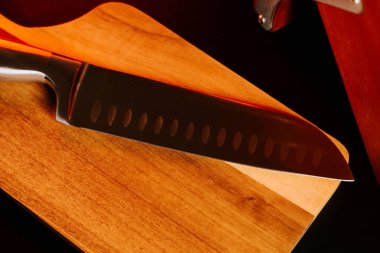 Keskin bıçak, akşamları mutfakta tahta kesme tahtasına dayanır.