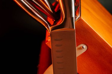 Mutfak ortamında yansıması ve ışıklandırma efektleri olan tahta bloktaki bıçaklar.