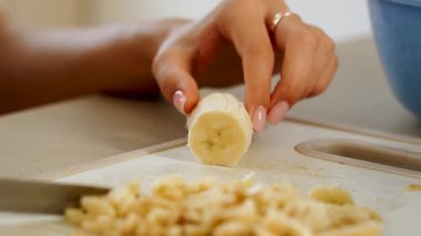 Evde mutfakta muz tabağı pişirmek bıçakla ve kesim tahtasıyla.