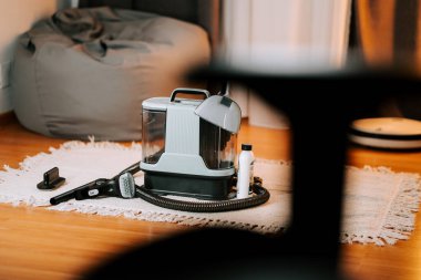 Temizlik sırasında oturma odasındaki bir halıya yerleştirilmiş elektrikli süpürge.