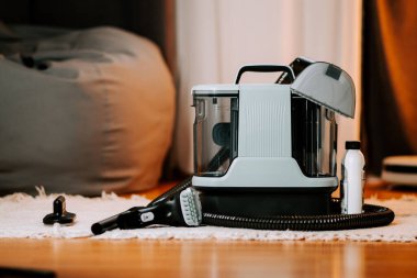 Oturma odası ortamında daha iyi performans için elektrikli süpürge temizliyorum.