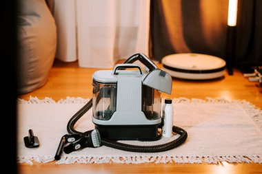 Ev ortamında temizlik için halının üzerine yerleştirilmiş elektrikli süpürge.