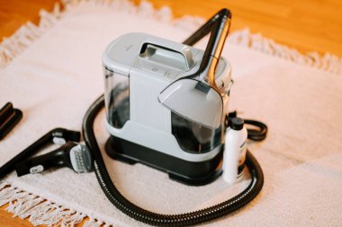 Gün ortasında evdeki elektrikli süpürgeyi oturma odasındaki yumuşak halıda temizlemek.