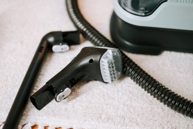 Evde temizlik için elektrikli süpürge parçaları yıkıyorum.