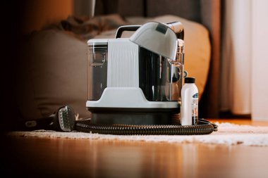 İçerideki ahşap zeminde temizlik yaparken elektrikli süpürge yıkamak.