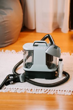 Günlük kullanımdan sonra rutin temizlik için oturma odasında elektrikli süpürge.