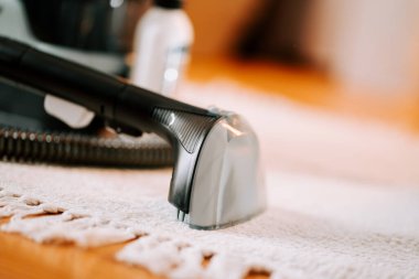 Tahta bir masayı temizlemek için elektrikli süpürge.