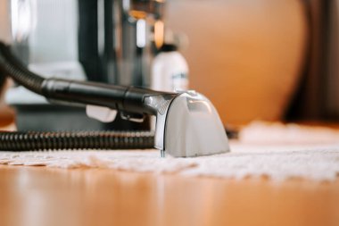 Evde temizlik yaparken ahşap yüzey üzerinde elektrikli süpürge başı yıkamak