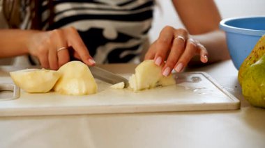 Mutfakta meyve hazırlayan bir kadınla armut dilimlemek.