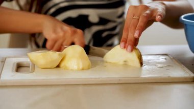Mutfakta bir insan tarafından kesme tahtasına bıçakla armut dilimlemek.