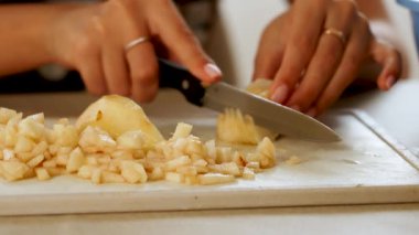 Gündüz vakti mutfakta kesme tahtasındaki armudu dilimlemek.