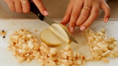 Mutfakta armudu küçük parçalara ayırmak keskin bir bıçakla tahta kesme tahtasının üzerinde