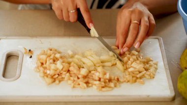 Mutfakta kesme tahtasındaki armudu dilimlemek.