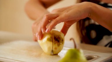 Parlak bir mutfakta kesme tahtasındaki armudu dilimlemek.