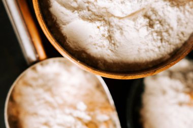 Ahşap kaselerde un ve metal kepçeler mutfak ortamında pişirilmeye hazır.