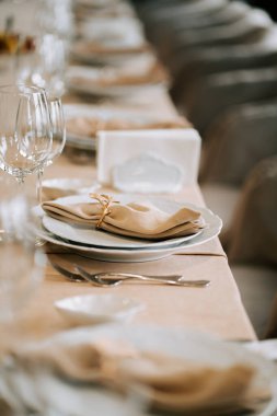 Gündüz saatlerinde geniş bir salonda akşam yemeği için şık bir sofra.