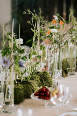 Çiçekler ve yeşillik özel bir toplantı için bir yemek masasında düzenlenir.