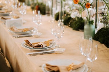 Parlak bir odada çiçek ve cam eşyalar olan özel bir etkinlik için şık bir masa.