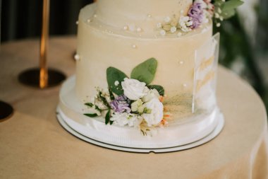 Öğleden sonra bir etkinlik salonunda yuvarlak bir masada çiçek desenli katlı pasta.