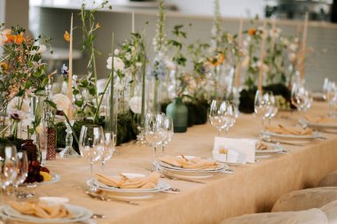 Parlak ışıkta özel bir etkinlik için çiçekli ve camlı zarif bir masa.