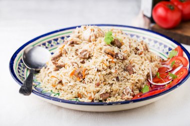 Geleneksel Özbek pilavı (plov) domates ve kırmızı soğan ile