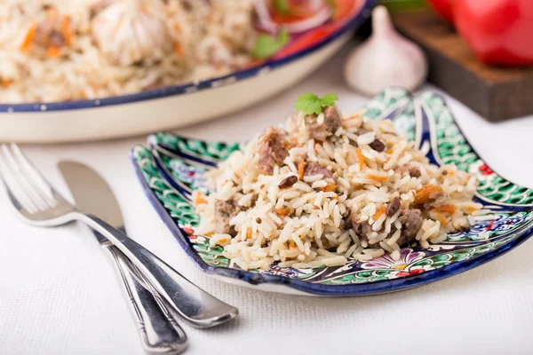 Geleneksel Özbek pilavı (plov) domates ve kırmızı soğan ile