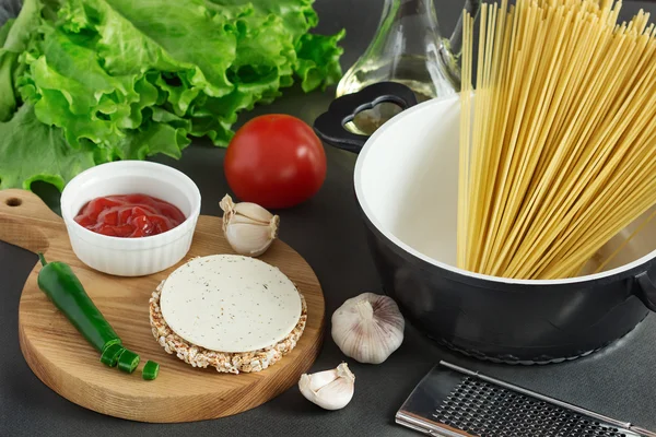 Pasta spaghetti, vegetables and spices on grey background — Stock Photo, Image