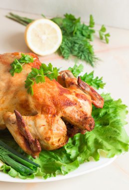 Taze sebze ve otlar üzerinde eğe ile bir bütün tavuk ızgara