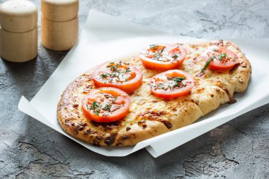 Peynir ve kırmızı domates pizza, yeşil bir beton b baharat.