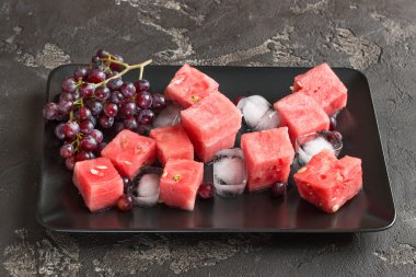 Dilimli karpuz, üzüm tatlı bir plaka üzerinde 
