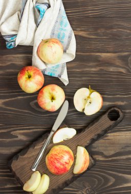 Bir ahşap tahta üzerinde olgunlaşmış bütün ve dilimlenmiş elma görünümü top