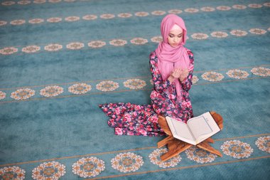 Genç Müslüman niyaz, ondan önce onun ellerinde kıble yönünü oturan Kur'an okur dua, biten tanık, dua Rukn