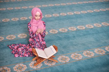 Genç Müslüman kıble yönünde oturan Kur'an, diz eller okur, dua biten, şahit, dua Rukn
